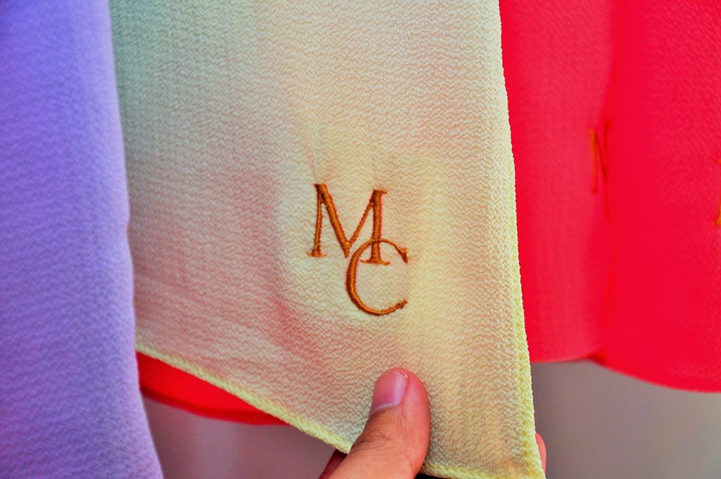 Headscarves that are monogrammed with the initials of the company, one of the many pieces offered by the local company.