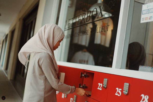 A staff of Letterbox checking out the store's unique collection system designed by Wa'iz. Customers are given a pin so they can collect their items at any time of the day. Picture: Hj Safwan
