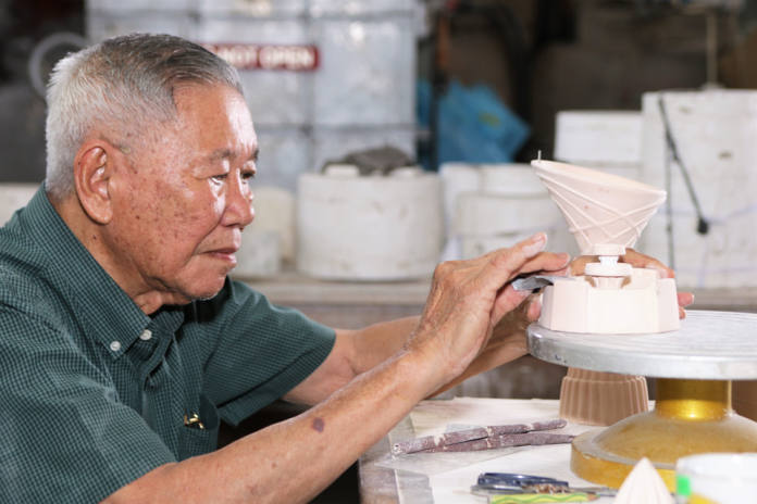 181218AW-maha (2) Hj Adnin using sandpaper to smoothen out a ceramic souvenir at Maha Seramik in Mumong. Photos by Faza Suraj.
